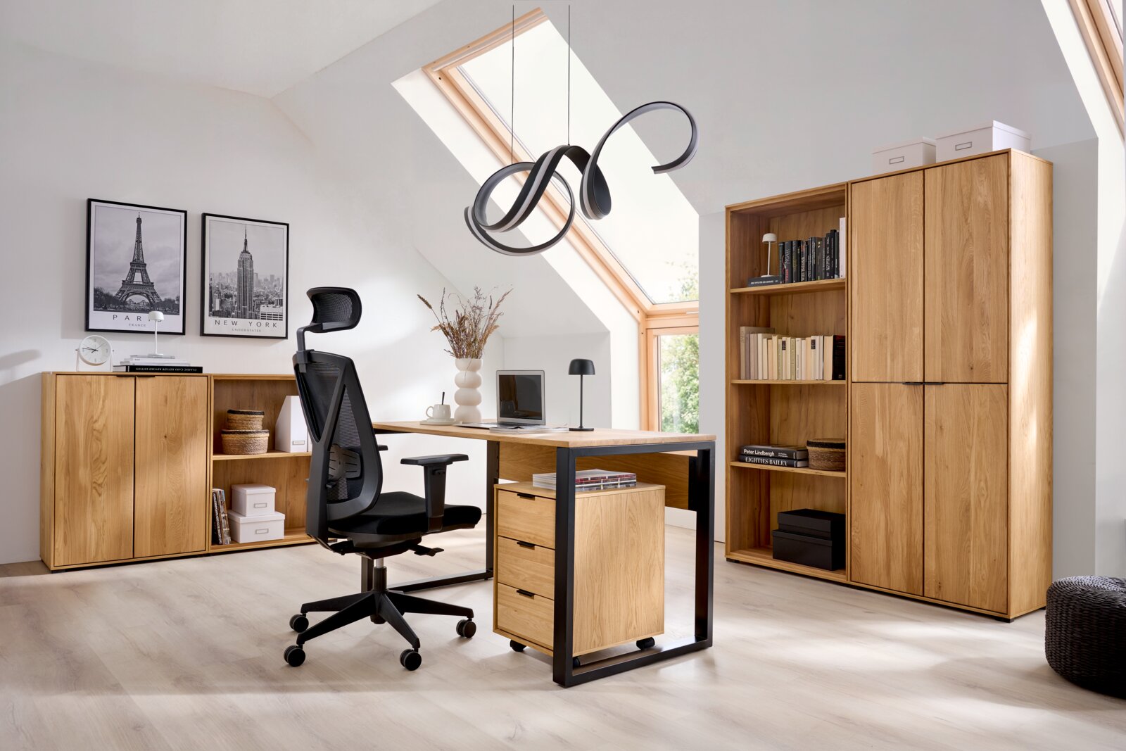 Modernes Homeoffice unter Dachschräge mit Holz-Schreibtisch auf schwarzem Metallgestell, Rollcontainer und ergonomischem Bürostuhl, daneben Holzregal und Sideboard; Perspektive: frontale Weitwinkel-Ansicht auf die komplette Einrichtung.