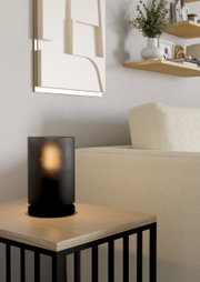 Moderne Tischleuchte COLOMERA in schwarzem, geripptem Design auf einem Holztisch, seitliche Perspektive.