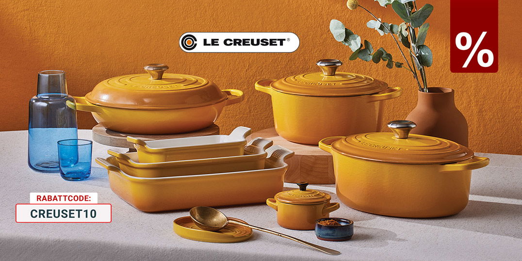 Le-Creuset Gusseisen-Töpfe und Auflaufformen in Gelb-Orange auf gedecktem Tisch
