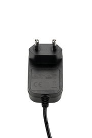 Schwarzes Netzteil mit zwei runden Steckern, von oben betrachtet.