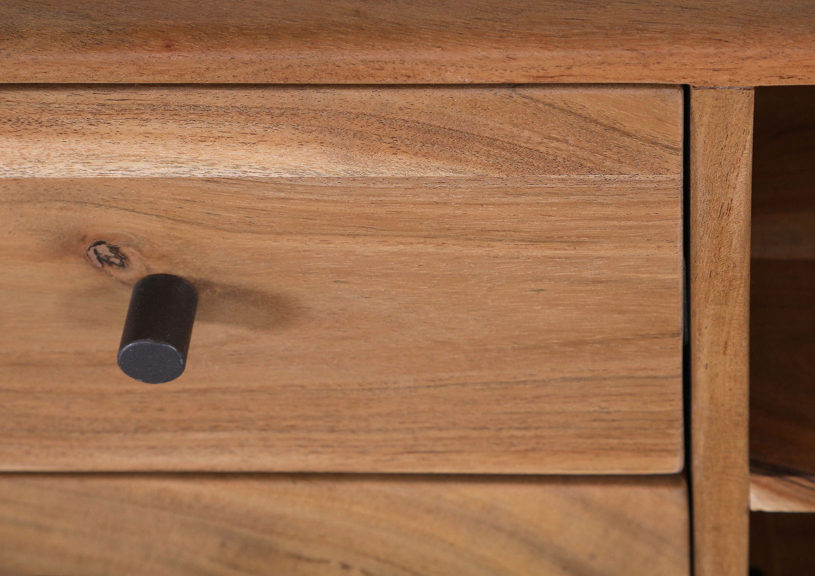 Nahaufnahme einer Holzschublade mit schwarzem Knopfgriff, perspektivisch von vorne.