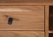 Nahaufnahme einer Holzschublade mit schwarzem Knopfgriff, perspektivisch von vorne.