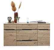 Frontale Ansicht eines modernen Sideboards aus Holz mit mehreren Schubladen und dekorativen Gegenständen darauf, darunter eine Vase mit getrockneten Blättern, eine Büste und Bücher.