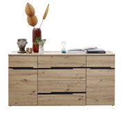 Frontale Ansicht eines modernen Sideboards aus Holz mit mehreren Schubladen und dekorativen Gegenständen darauf, darunter eine Vase mit getrockneten Blättern, eine Büste und Bücher.