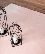 Rosa Teppich Loft Rose ca. 120x160cm auf Holzboden, mit zwei dekorativen schwarzen Laternen und weißen Kerzen, aus der Vogelperspektive.