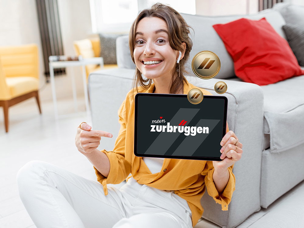 Lächelnde Frau zeigt ein Tablet mit Kundenprogramm und Bonuspunkten im Wohnzimmer.