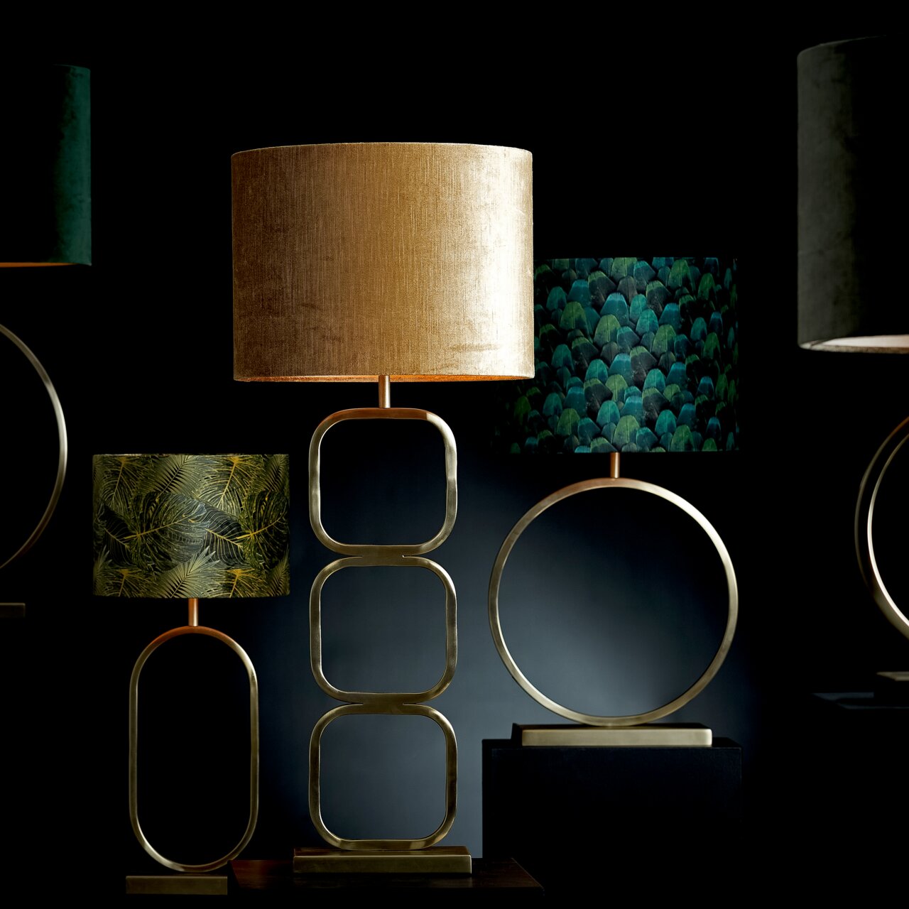 Lampenschirm Zylinder in Gold, frontal betrachtet, auf einem modernen, geometrischen Lampenfuß.