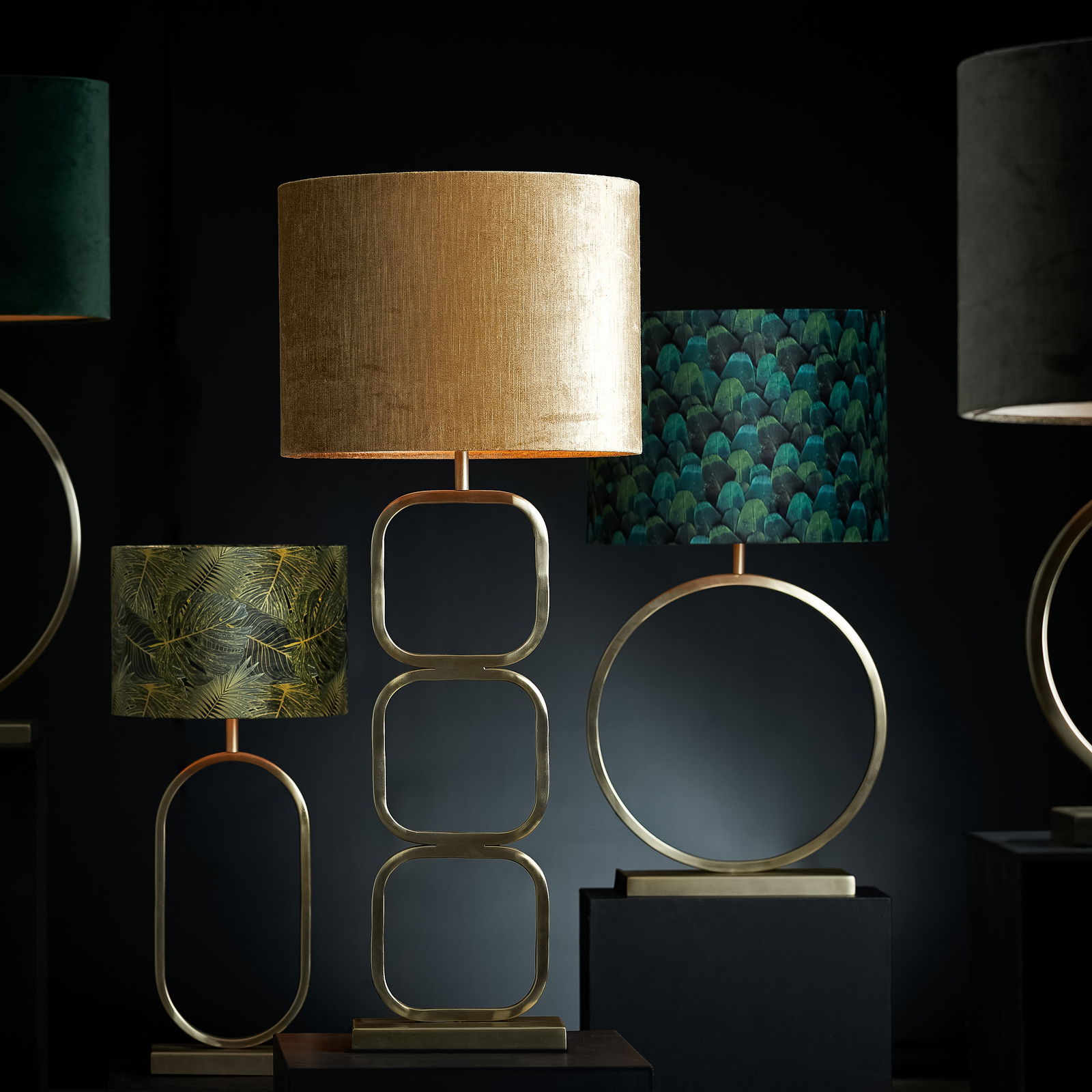 Lampenschirm Zylinder in Gold, frontal betrachtet, auf einem modernen, geometrischen Lampenfuß.