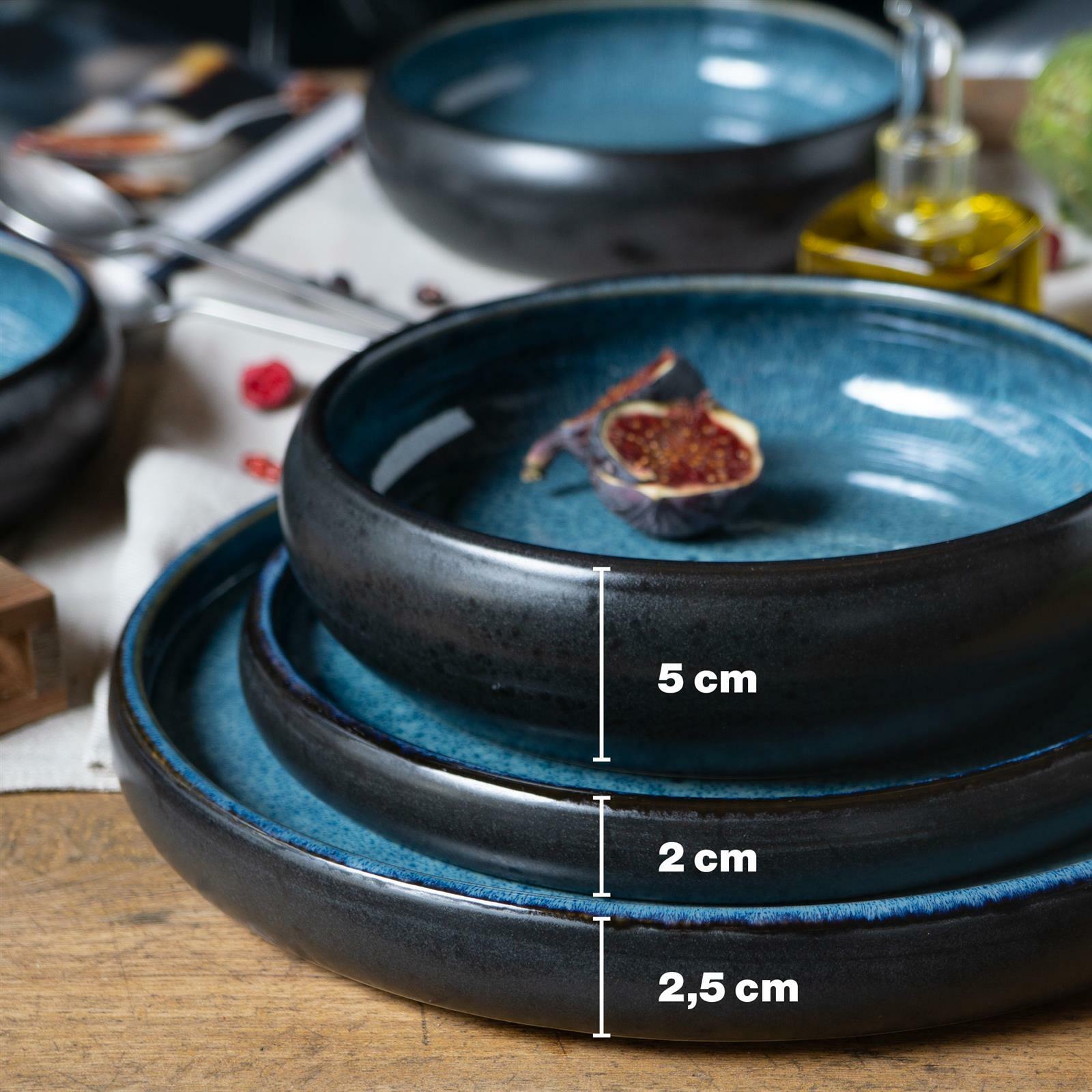 Dreiteiliges blaues Tafelservice in Nahaufnahme, gestapelt mit Höhenangaben von 5 cm, 2 cm und 2,5 cm, auf einem Holztisch mit einer Feige als Dekoration.