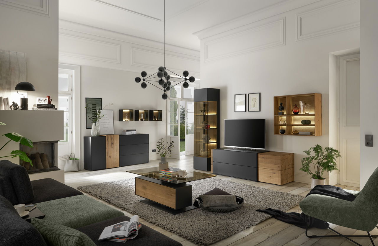 Musterring Wandkombination TREVIO Moderne Wohnzimmer-Wandkombination in einem stilvollen Raum mit schwarzem und holzfarbenem Design, inklusive TV-Schrank, Vitrine und Regalen. Perspektive: Frontalansicht.
