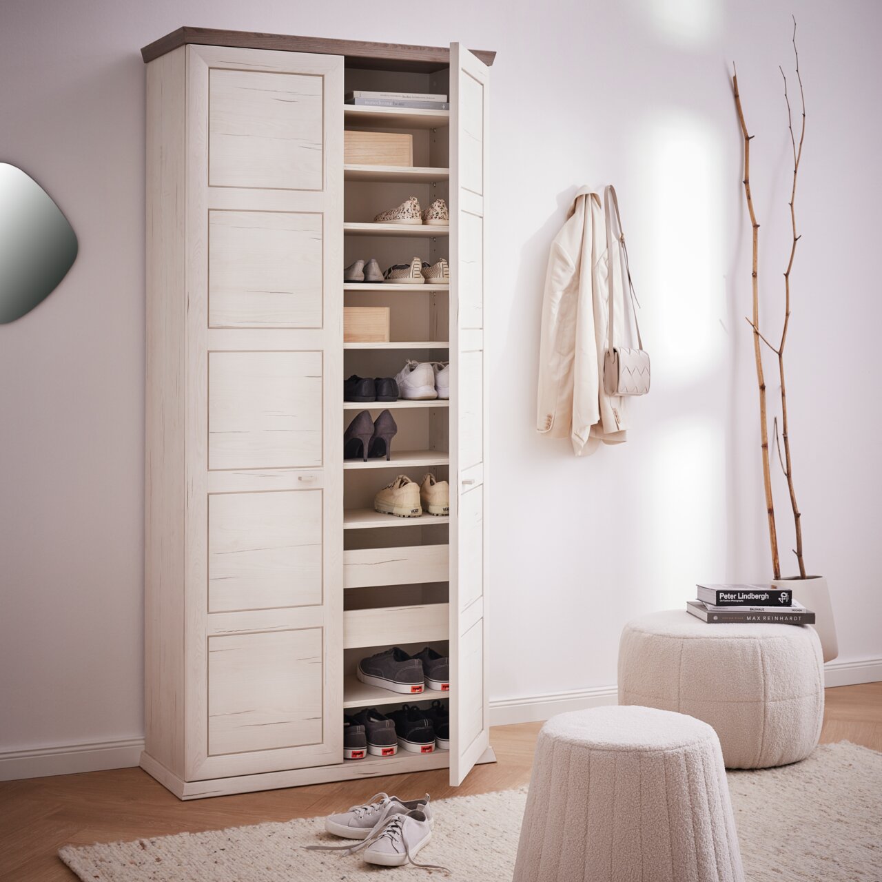 Hochformatiger Schrank mit offenen Türen, gefüllt mit Schuhen und Boxen, in einem modernen Raum mit hellem Holzfußboden und minimalistischer Dekoration.