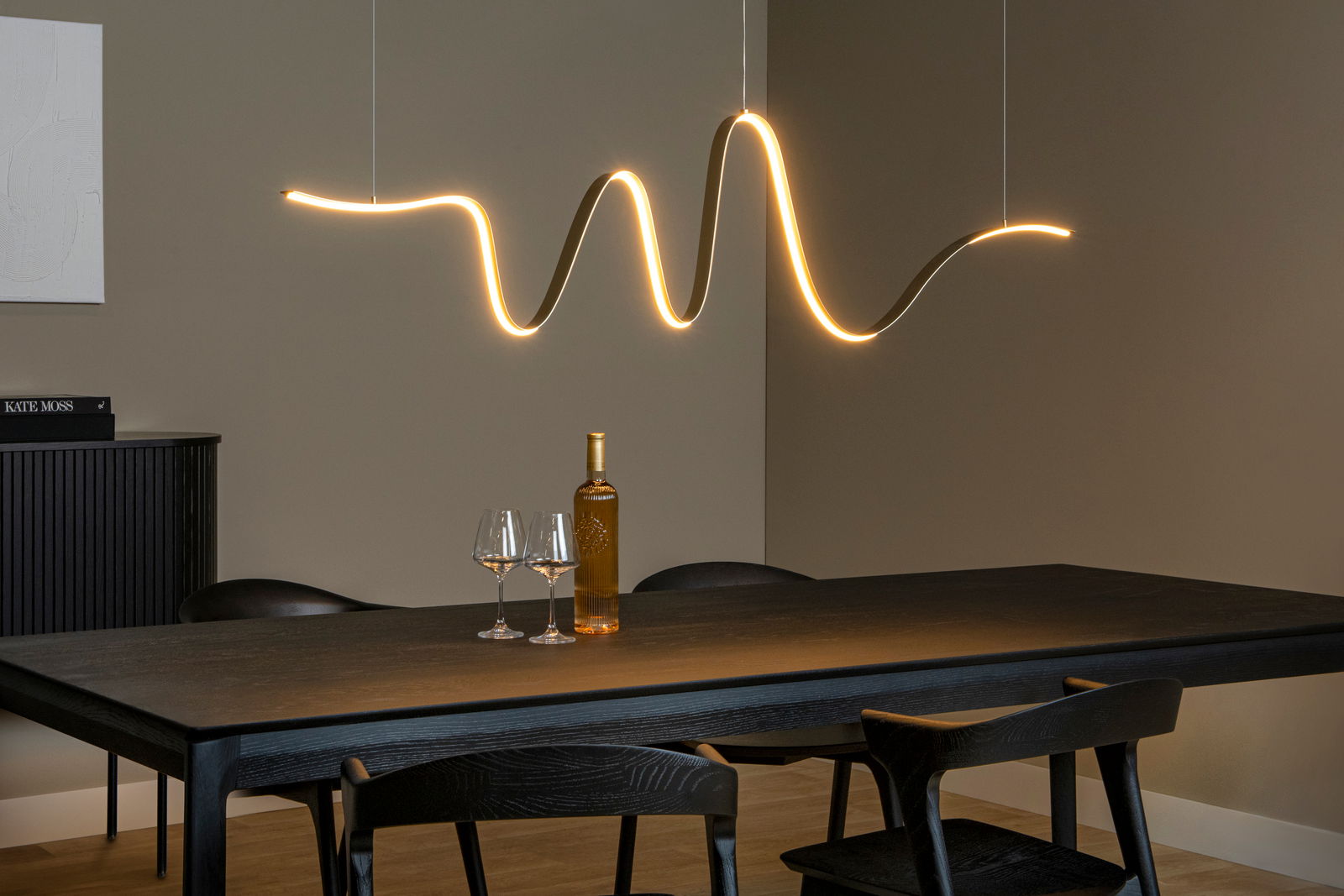 Lucide Hängeleuchte LAMBADA Moderne Hängeleuchte in wellenförmigem Design über einem Esstisch, seitliche Perspektive