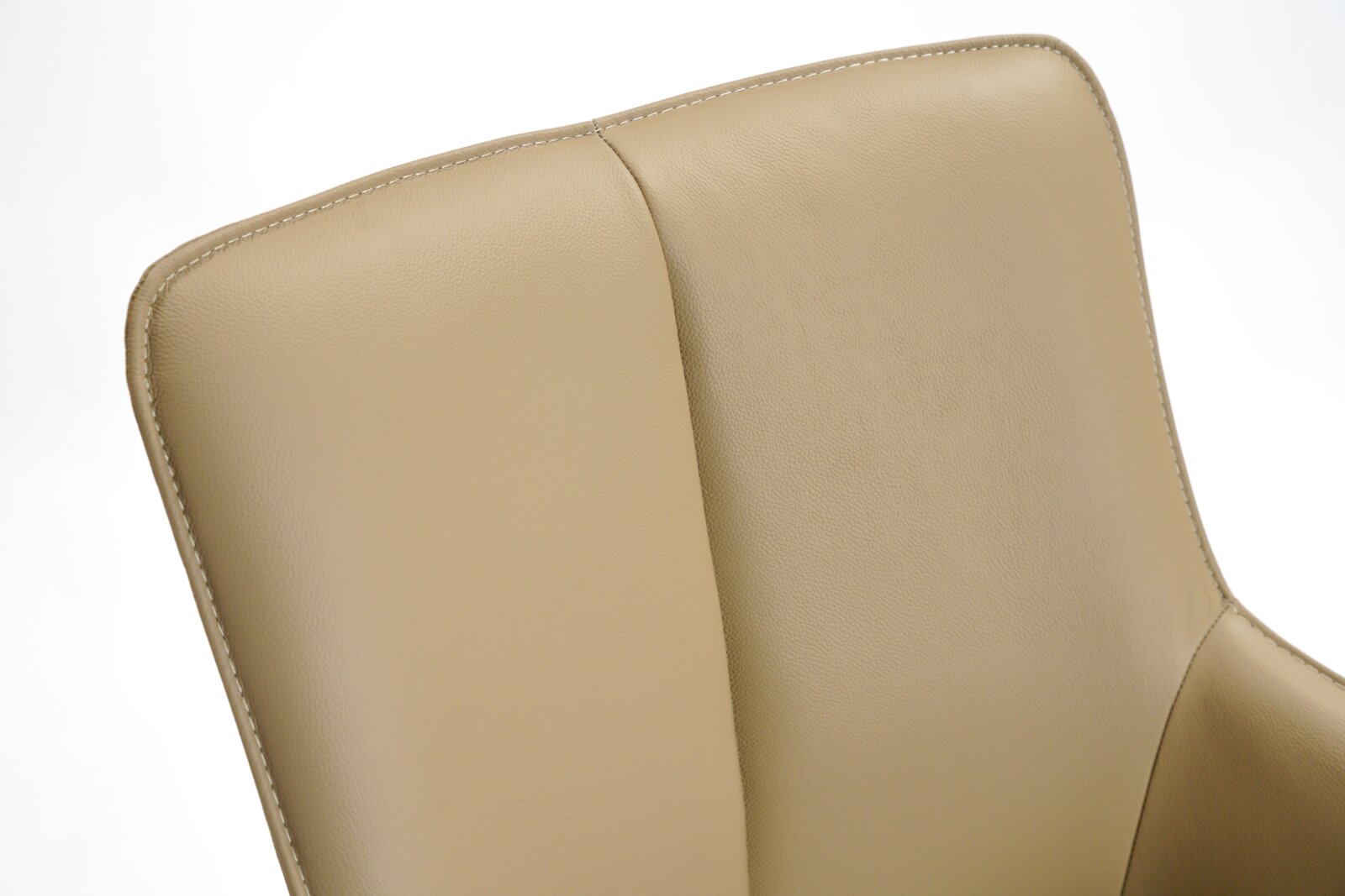 Close-up van de rugleuning van een beige leren fauteuil, gezien vanaf de voorkant.