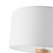 Nahaufnahme eines weißen Lampenschirms einer Stehleuchte mit Holzdetail.