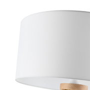 Nahaufnahme eines weißen Lampenschirms einer Stehleuchte mit Holzdetail.