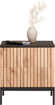 Nachtkommode aus Holz mit vertikalen Streifen, schwarze Tischplatte, dekoriert mit einer Vase und Zeitschriften, Frontalansicht