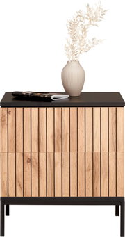 Nachtkommode aus Holz mit vertikalen Streifen, schwarze Tischplatte, dekoriert mit einer Vase und Zeitschriften, Frontalansicht