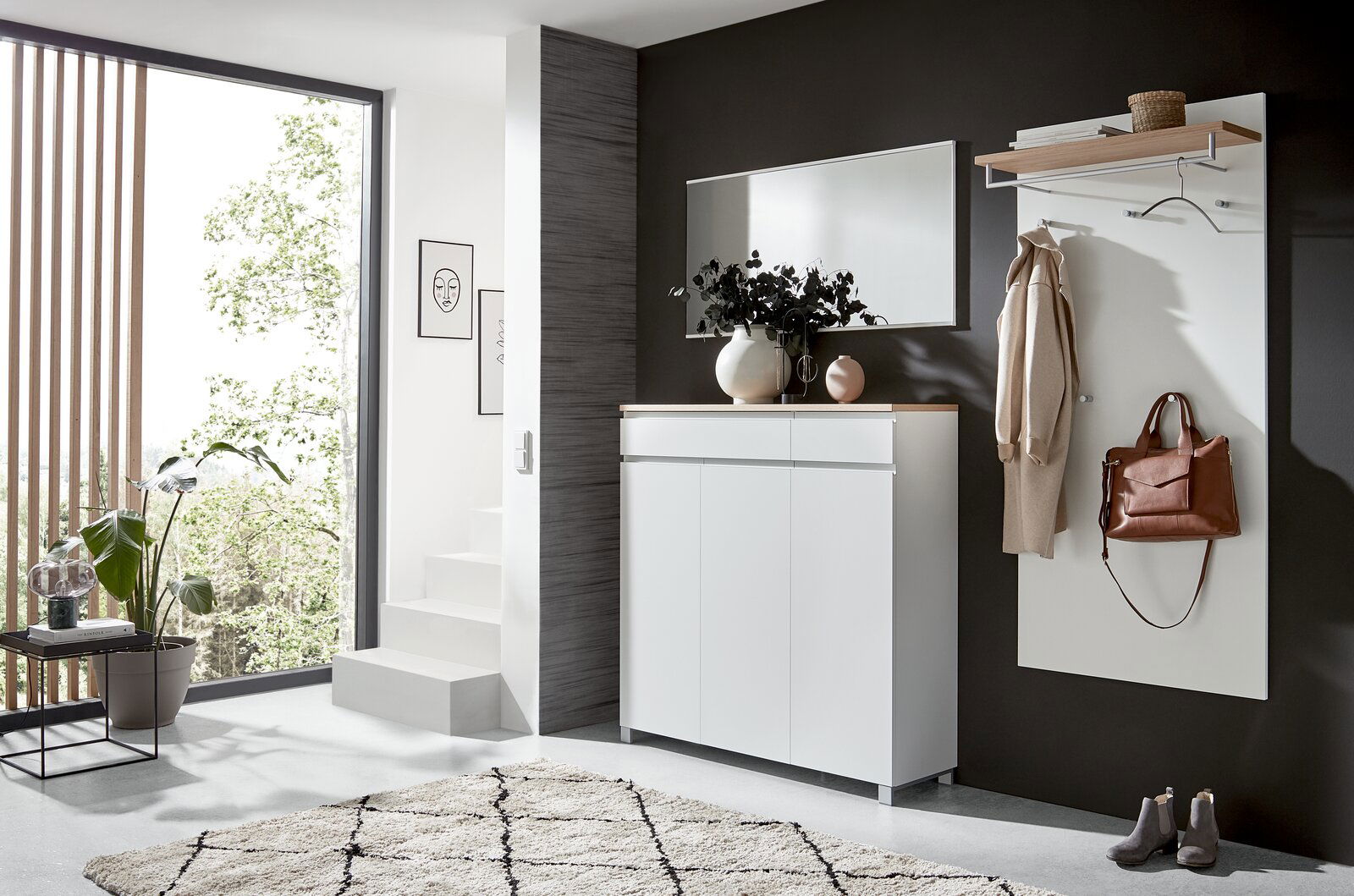Dieter Knoll Schuhschrank SORRENT Moderner Eingangsbereich mit weißem Schuhschrank, Spiegel und Garderobenpaneel. Perspektive von der Seite.