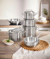 Topfset Gourmet Plus 6-tlg. aus Edelstahl, bestehend aus mehreren Töpfen und Pfannen mit Deckeln, auf einer Küchenarbeitsplatte von vorne fotografiert.