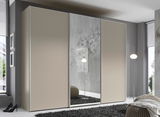 Moderner Schwebetürenschrank in Beige mit Spiegel in einem stilvollen Schlafzimmer, seitliche Perspektive.