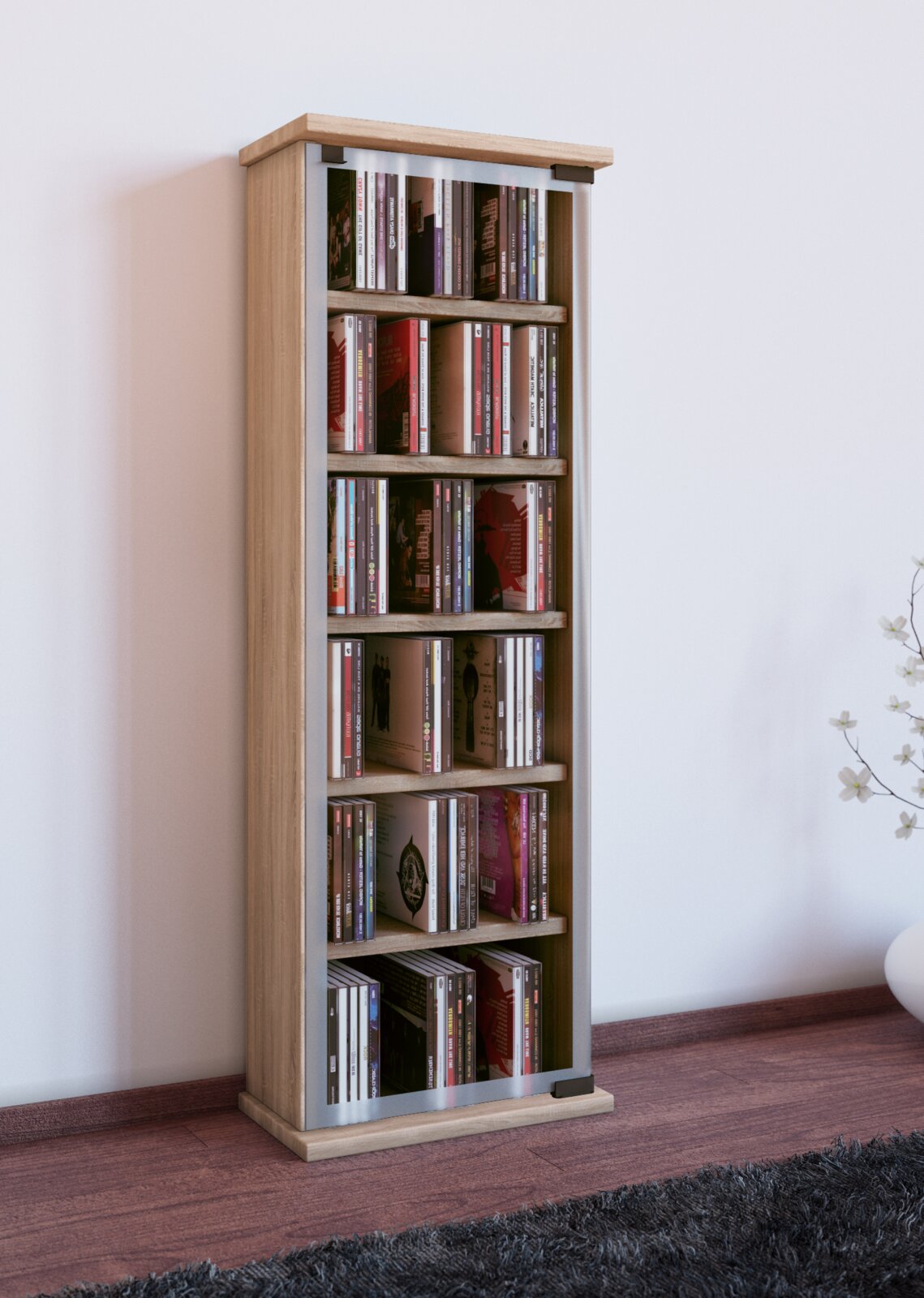 Schmales CD-/DVD-Regal in Holzoptik mit silberfarbenem Rahmen, gefüllt mit CDs, freistehend im Raum; Perspektive: frontale Ansicht mit leichtem Blick von links