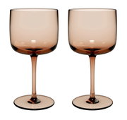 Zwei elegante Weinkelche aus braunem Glas, frontal fotografiert.
