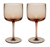 Zwei elegante Weinkelche aus braunem Glas, frontal fotografiert.