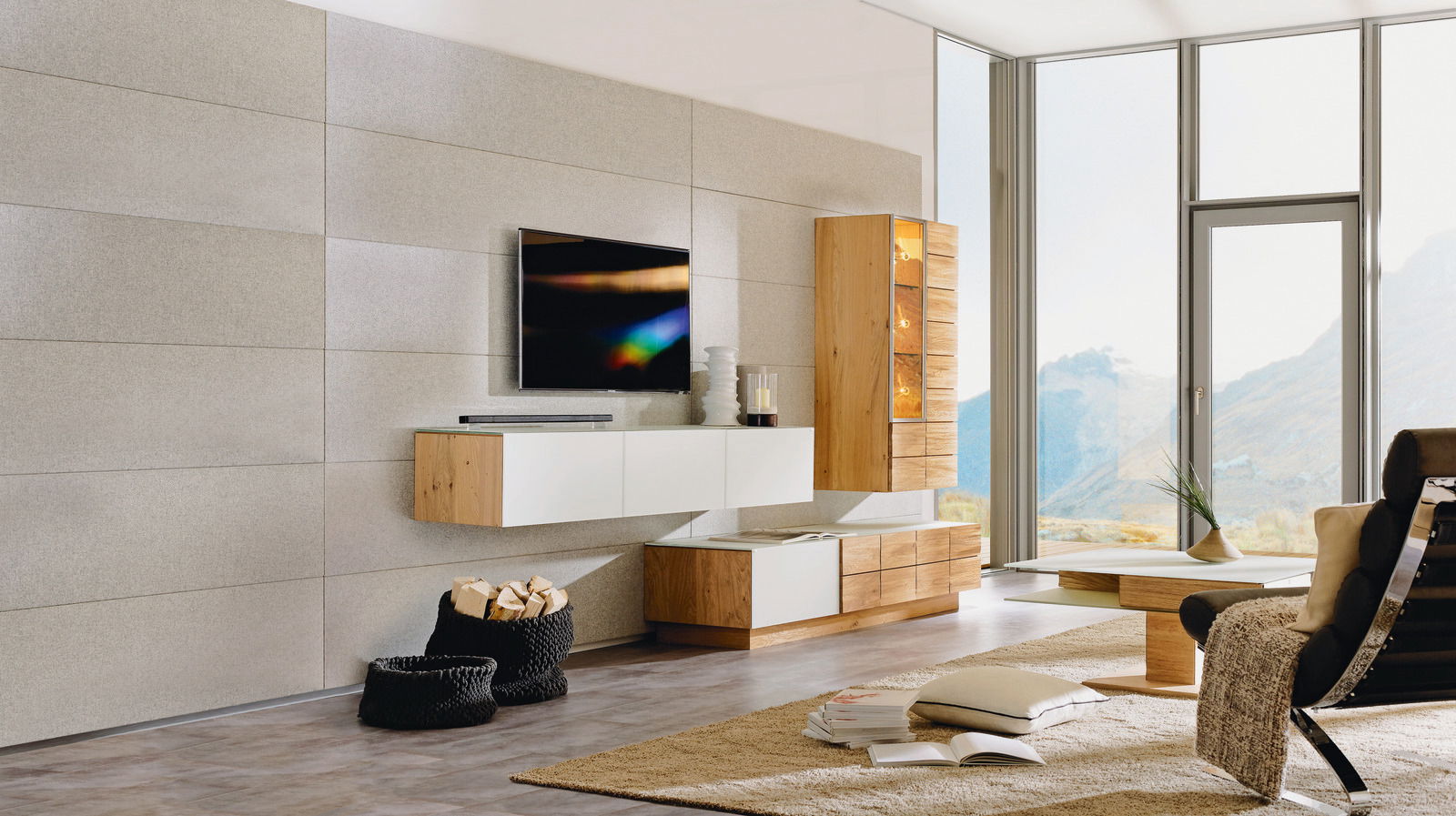 Moderne Wohnwand ohne Beleuchtung in einem hellen Wohnzimmer mit großen Fenstern, bestehend aus hängenden und stehenden Elementen in Holz- und Weißtönen, seitliche Perspektive.