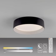 Runde, schwarze LED-Deckenleuchte mit weißem Diffusor an grauer Decke, perspektivisch von unten im leichten Winkel gezeigt; inkl. Fernbedienung für Dimmen und CCT-Farbtemperatur 2700–5000 K sowie Nachtlicht- und Memory-Funktion.