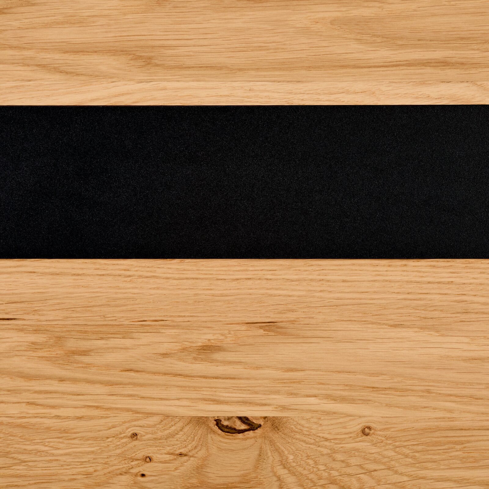 Detailfoto van een dressoir met houtnerf en een zwarte accentstrook