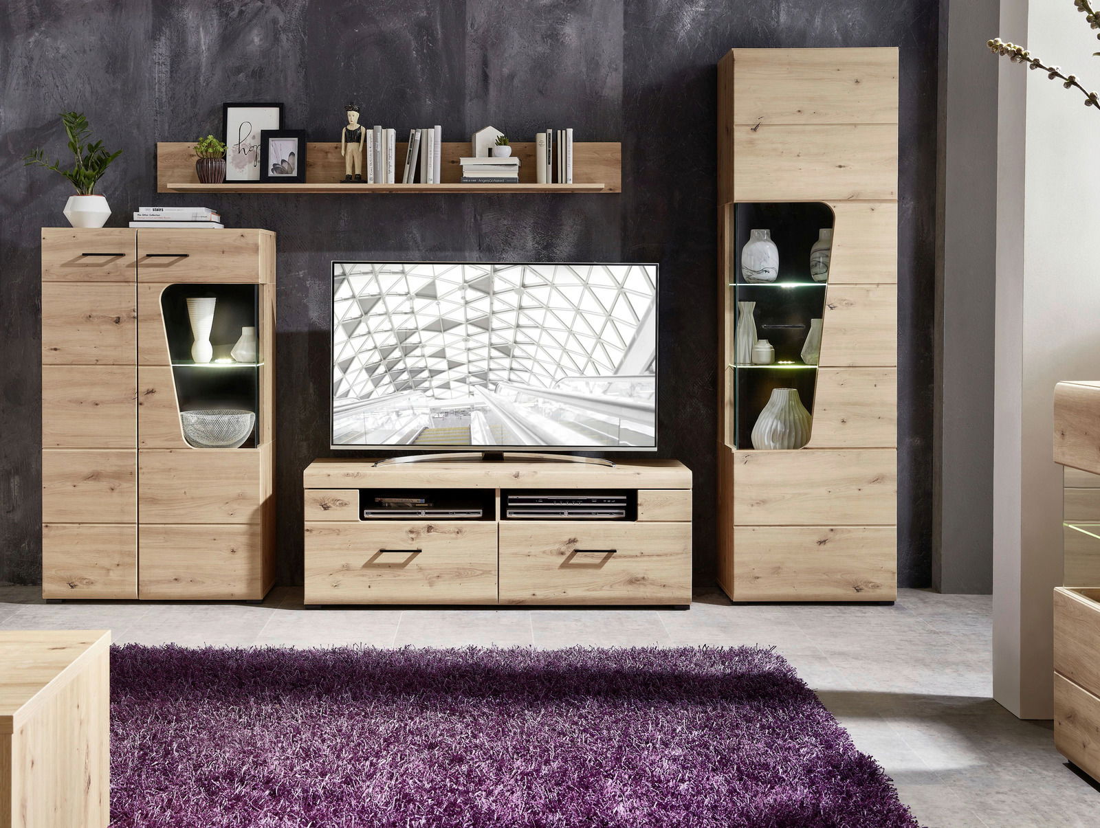 Wohnwand aus hellem Holz mit modernen Vitrinen und TV-Schrank, frontal fotografiert.