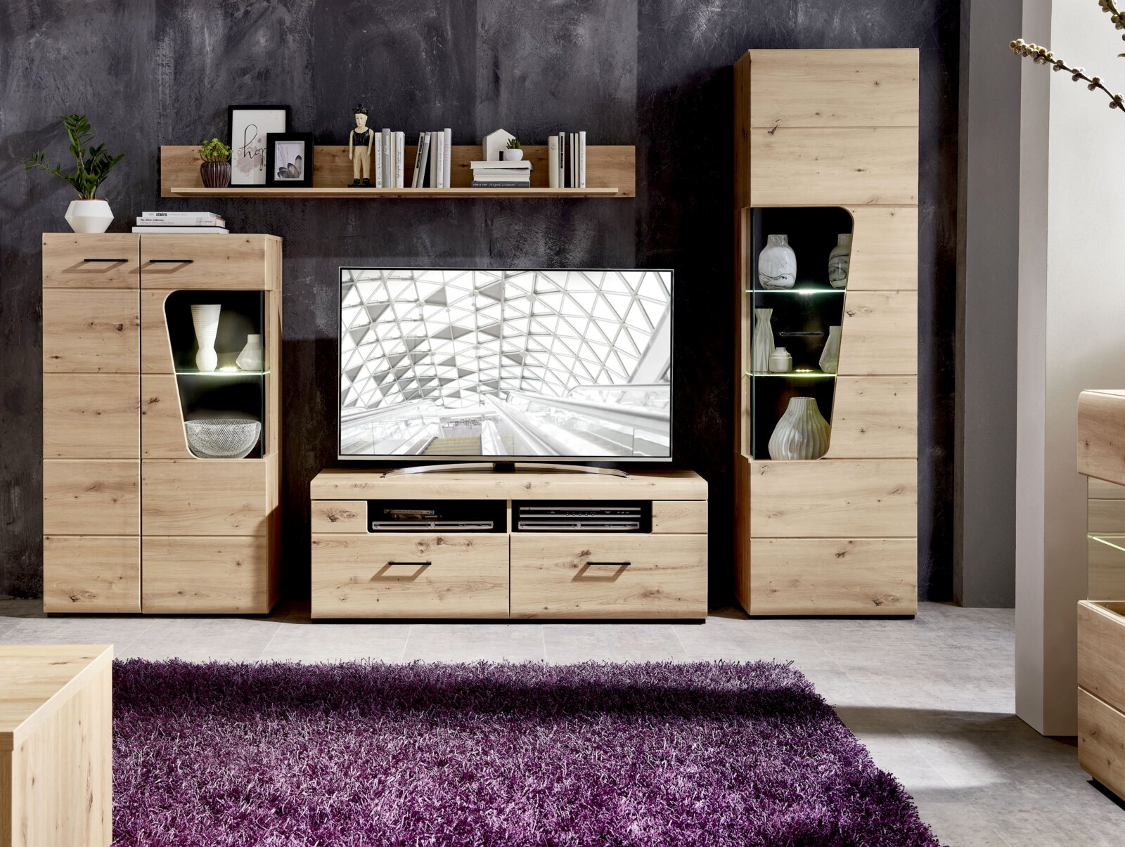 Wandmeubel van licht hout met moderne vitrinekasten en tv-kast, gefotografeerd vanaf de voorkant.