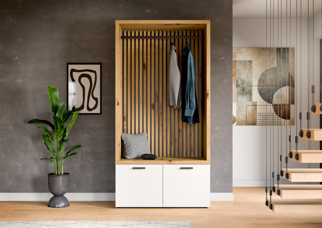 Vooraanzicht van een moderne compacte kledingkast met houten frame, verticale stangen en twee witte kastdeuren, versierd met kleding en een kussen.