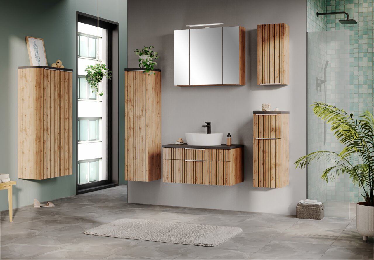 XORA Midischrank 60 cm JAKARTA Moderne Badezimmermöbel aus Holz mit vertikalen Lamellen, darunter ein Midischrank, aus der Perspektive eines hellen, stilvollen Badezimmers mit Pflanzen und großen Fenstern.