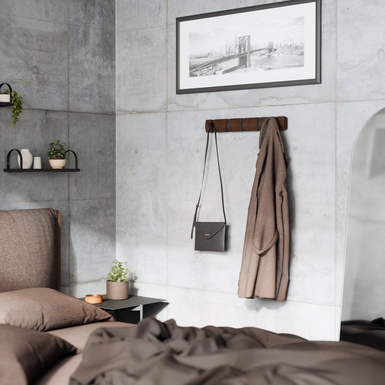 Umbra Wandgarderobe FLIP Wandgarderobe aus Holz mit mehreren Haken, an der eine braune Jacke und eine schwarze Tasche hängen, in einem modernen Schlafzimmer mit Betonwänden und minimalistischer Dekoration. Perspektive: seitlich.