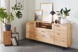 Holz-Sideboard mit mehreren Schubladen und Türen, dekoriert mit Pflanzen und Bildern, seitliche Perspektive