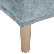 Nahaufnahme eines Hockers mit hellgrauem Stoffbezug und einem Holzbein, Perspektive von der Seite.