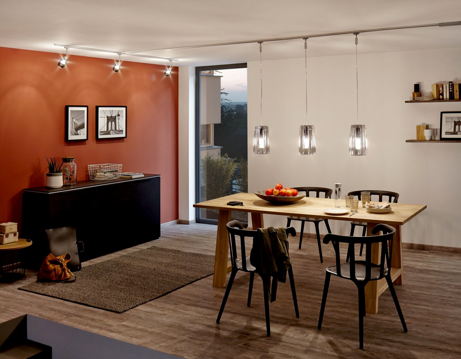 Esszimmer mit modernem Design, hängende Pendelleuchten über einem Holztisch, seitliche Perspektive