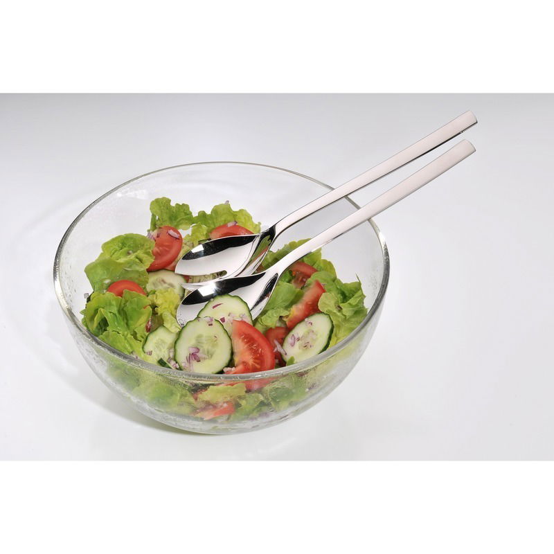 Glas-Salatschüssel mit frischem Salat und zwei Edelstahl-Servierlöffeln, seitliche Perspektive