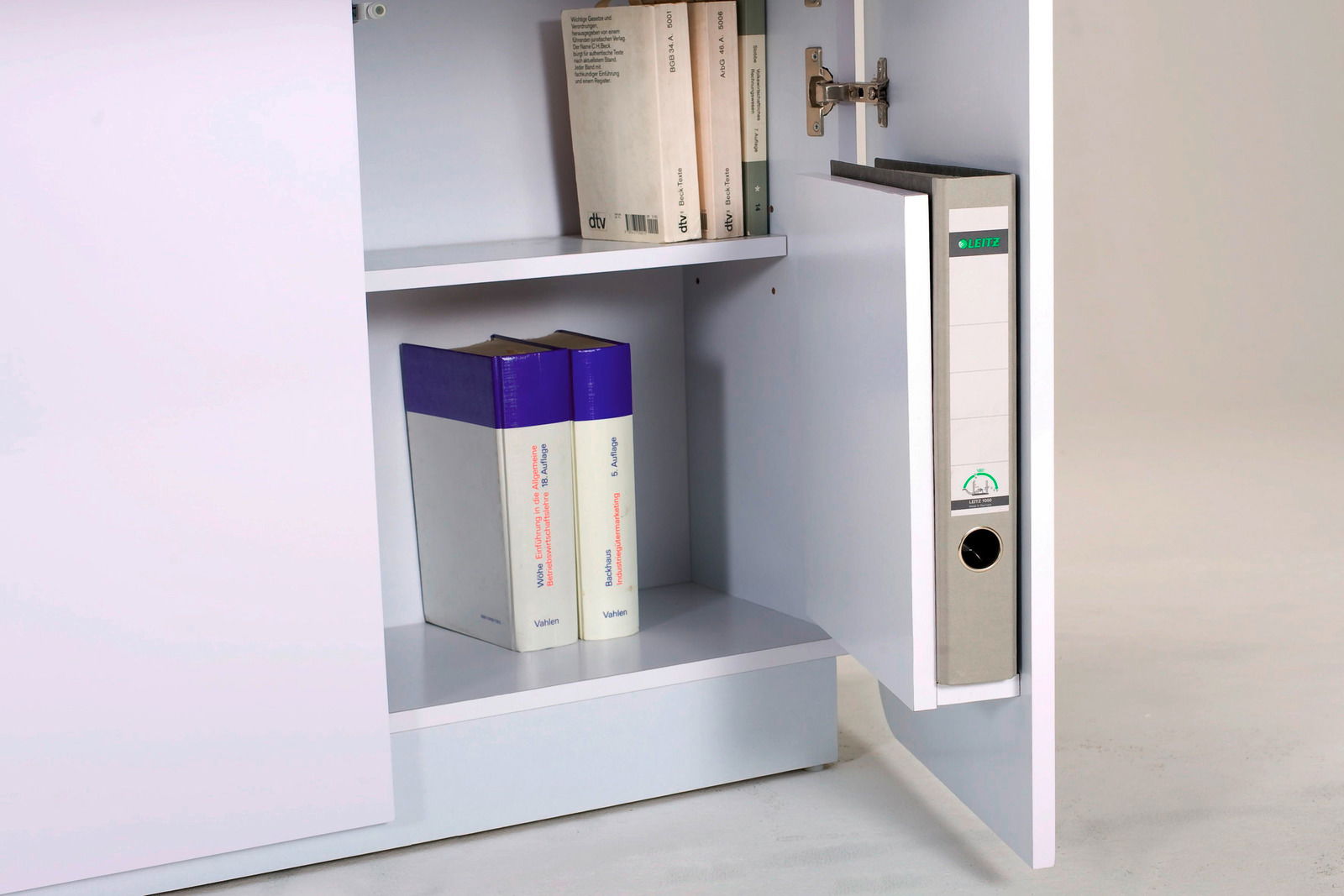 Offener Schrank mit Aktenordner und Büchern, seitliche Perspektive