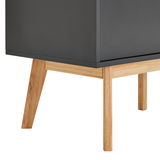 Nahaufnahme eines modernen Sideboards mit dunkler Oberfläche und hellen Holzbeinen, seitliche Perspektive