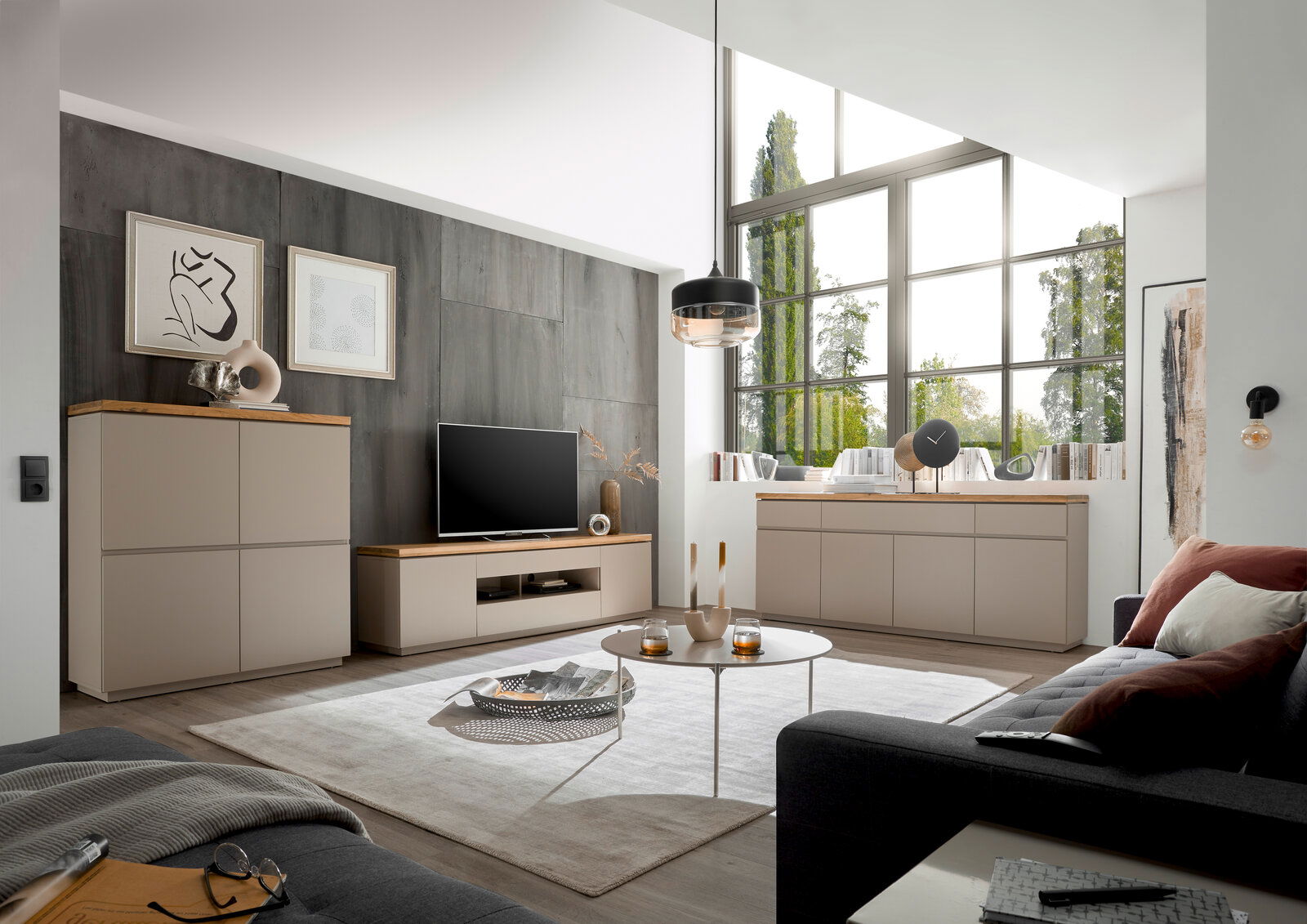 XORA XL-TV-Lowboard PALAMOS Modernes Wohnzimmer mit XL-TV-Lowboard, Sideboard und Highboard in heller Holzoptik, seitliche Perspektive.