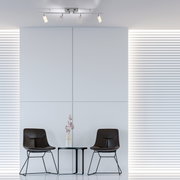 Moderne Deckenleuchte aus Aluminium mit vier verstellbaren Strahlern, von unten betrachtet in einem minimalistischen Raum mit zwei Stühlen und einem Tisch.