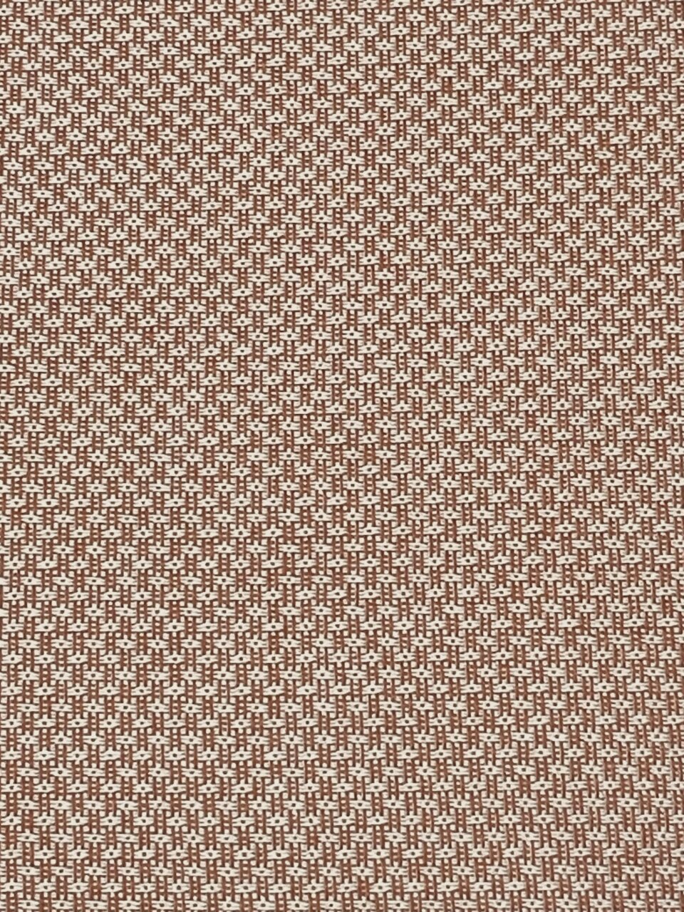 Close-up van een bruin-wit gedessineerde stof met een geweven structuur, gezien van bovenaf.