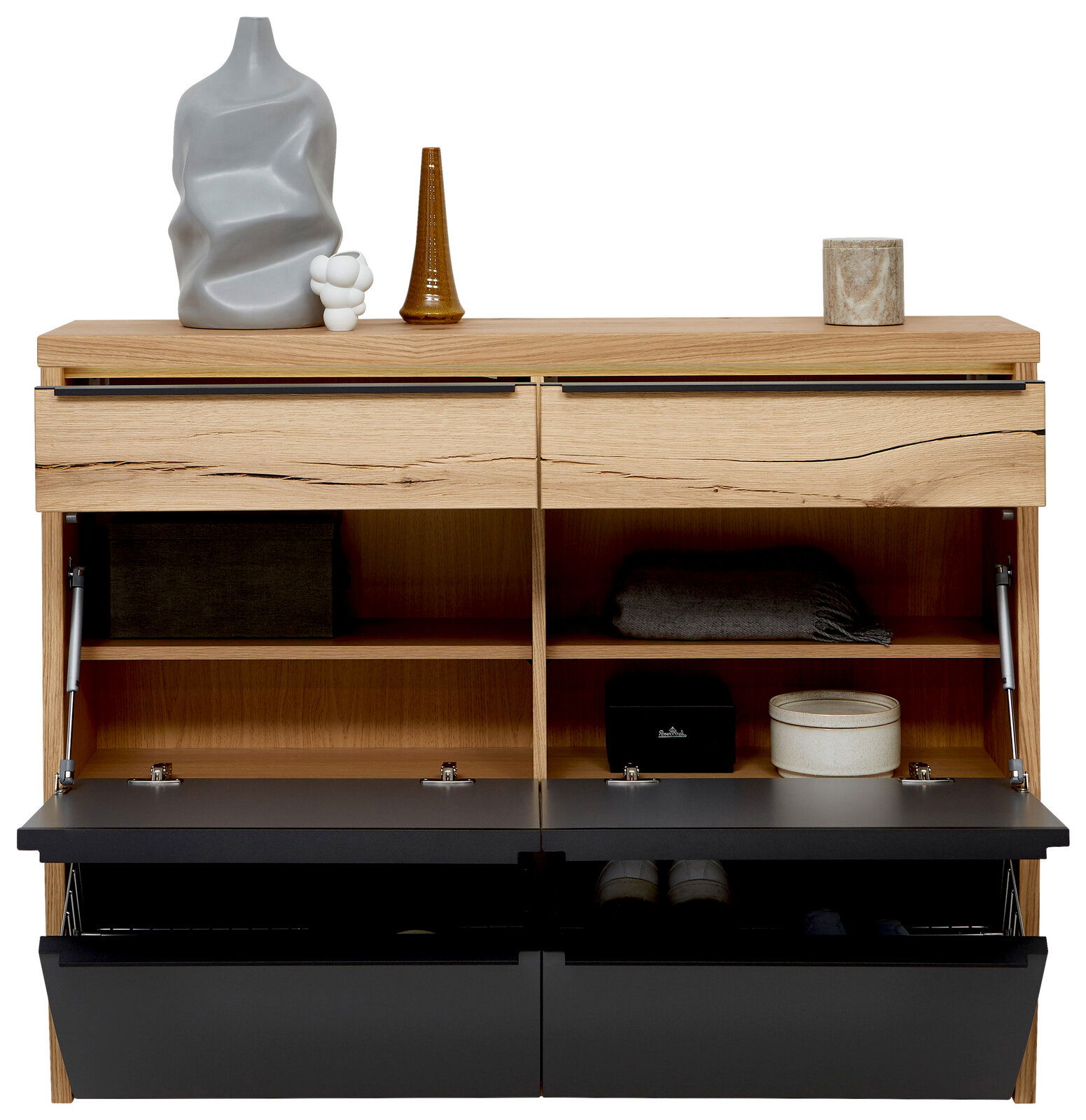 Offenes Schuhschrank-/Sideboard aus hellem Holz mit zwei oberen Schubladen und zwei nach vorn abklappenden schwarzen Fronten, Innenfächer sichtbar; dekoriert mit Vasen und Figur auf der Oberseite, Frontansicht.