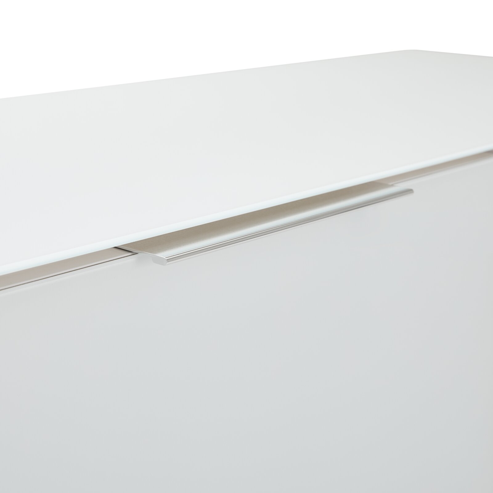 Nahaufnahme eines weißen Highboards mit modernem, silbernem Griff, von oben betrachtet.