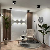 Moderne LED Wandleuchte in einem stilvoll eingerichteten Raum mit Pflanzen und gemütlichem Sessel, seitliche Perspektive.