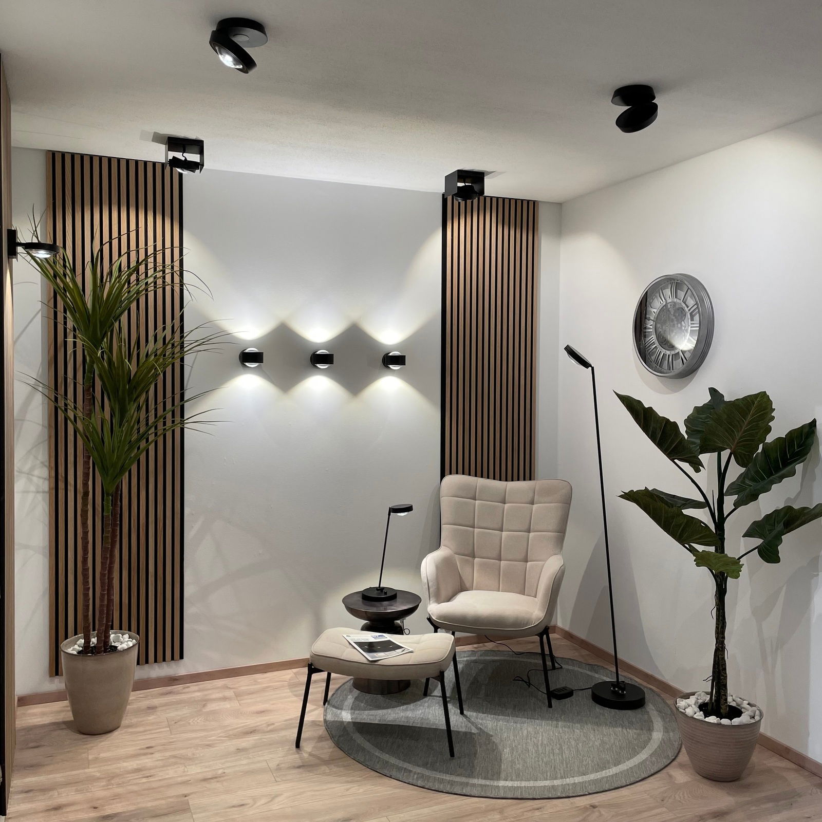 Moderne LED Wandleuchte in einem stilvoll eingerichteten Raum mit Pflanzen und gemütlichem Sessel, seitliche Perspektive.