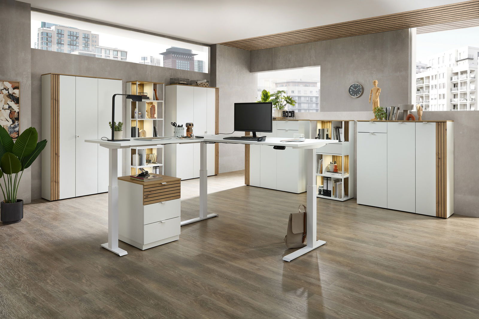 Moderne Büroumgebung mit höhenverstellbarem Eckschreibtisch, umgeben von weißen Büroschränken und Regalen, aus der Perspektive eines offenen Raumes mit großen Fenstern.