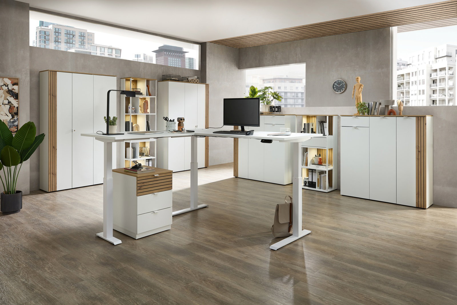 Moderne Büroumgebung mit höhenverstellbarem Eckschreibtisch, umgeben von weißen Büroschränken und Regalen, aus der Perspektive eines offenen Raumes mit großen Fenstern.